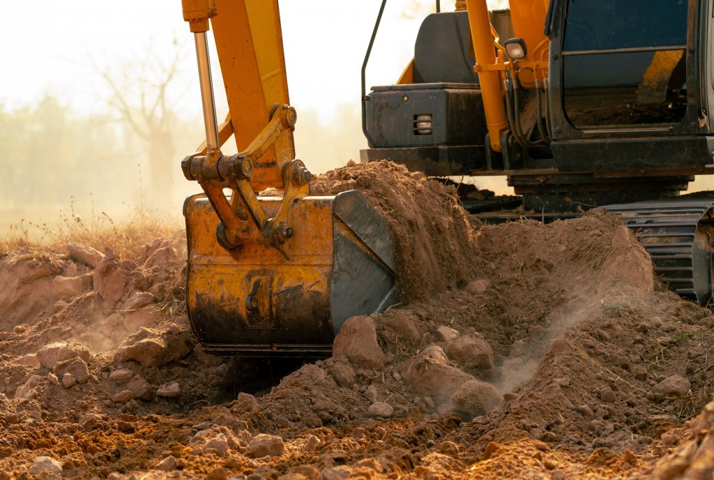 A yellow excavator is positioned on a construction site