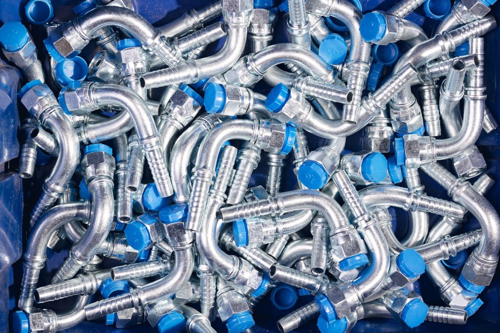 The image shows a variety of hydraulic hose end fittings, including BSP